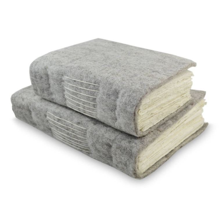 Two grey wool felt Nepali Yeti Tracker journals stacked, their stitched spines showing