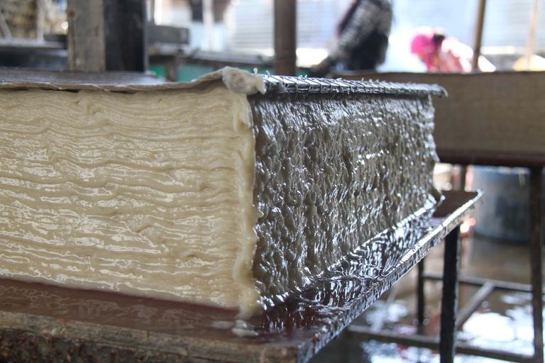 A stack of freshly made washi-method lokta sheets, still wet, in a workshop in Nepal