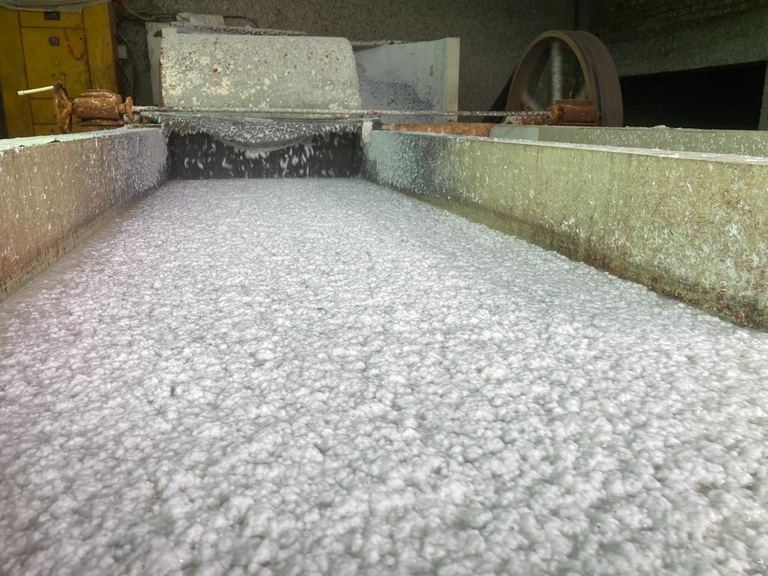 Creating cotton paper pulp from industrial garment manufacturing scraps: a long trough of wet white pulp at the mill in Jaipur