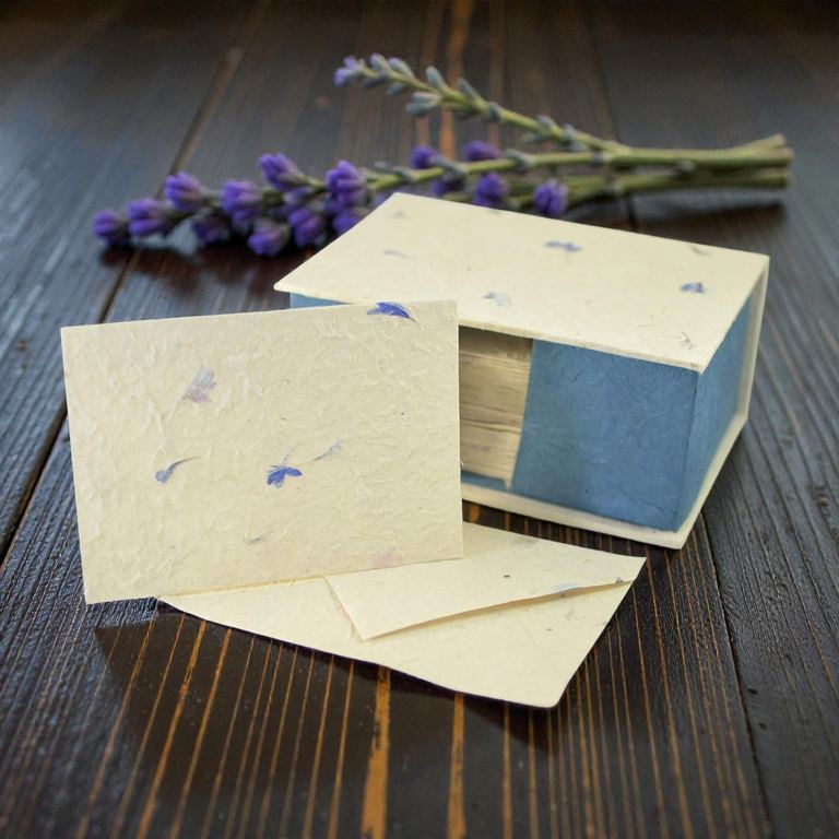 The 25-card Cornflower set with its blue-sided box on dark wood beside lavender