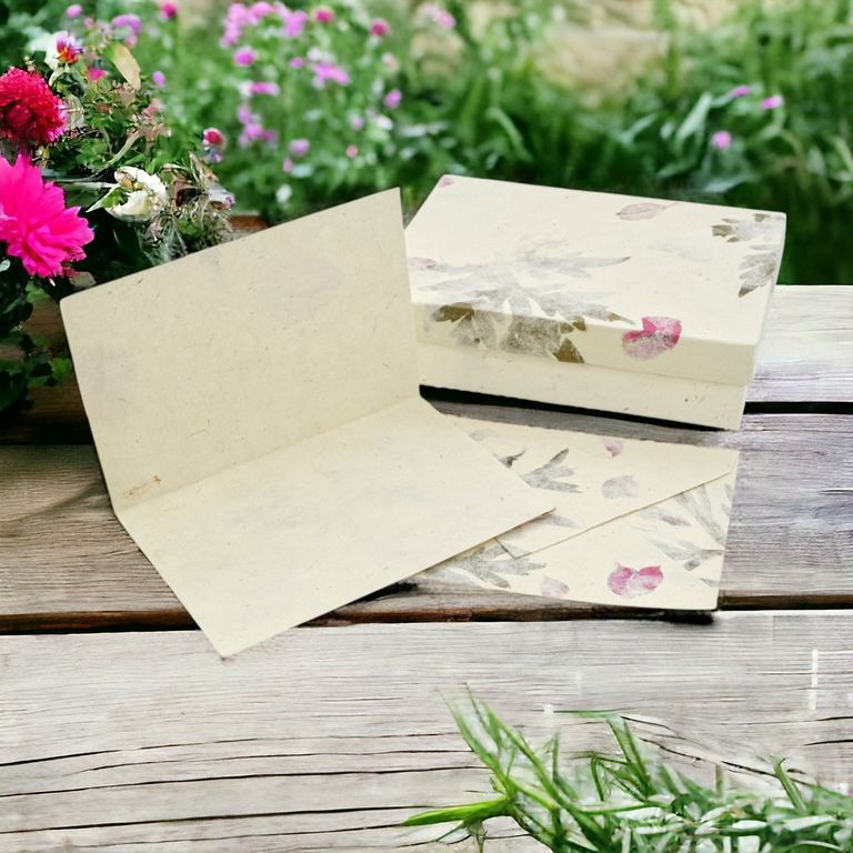 Forest Wanderer cards, envelopes and box on a weathered table among pink flowers