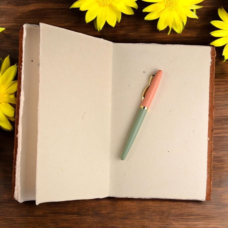 A Heritage Deluxe Companion notebook open to its thick, deckle-edged blank pages, a pen across them