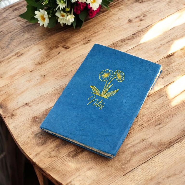 The Indigo Heritage Deluxe Companion notebook on a round wooden table