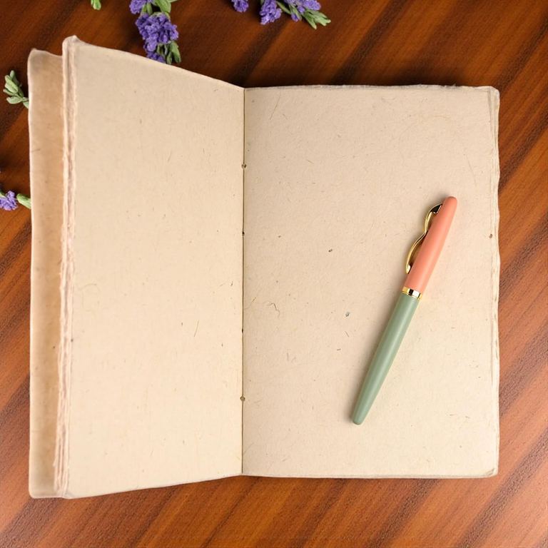 A Natural Heritage Deluxe Companion notebook open to its blank pages on a wooden table, yellow flowers behind