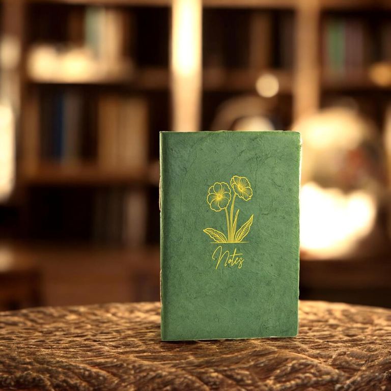The Sage Heritage Deluxe Companion notebook standing on a table in front of shelves of books