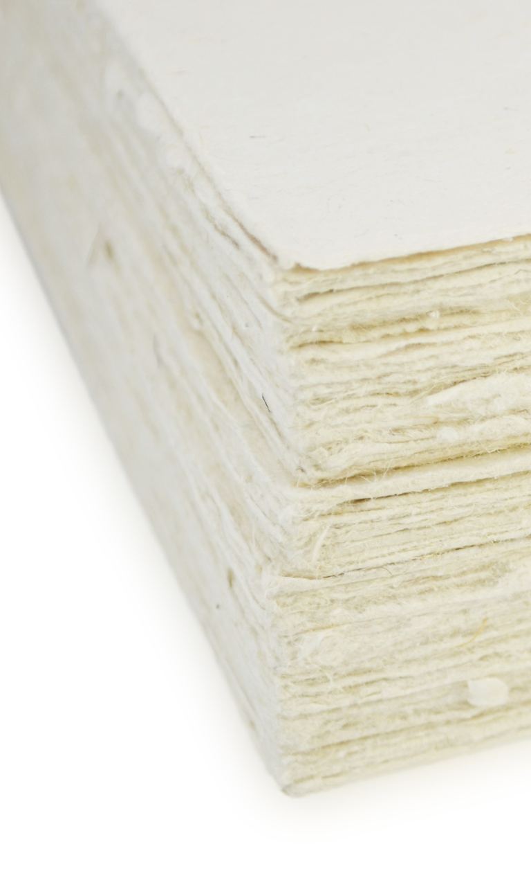 The deckled edges of a stack of Deluxe lokta card stock, close up