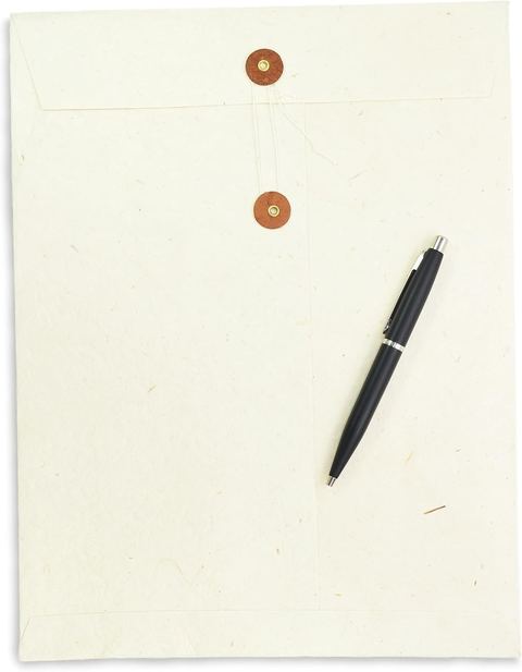 The 10 × 13 inch natural lokta envelope with terra cotta buttons, a pen beside it for scale