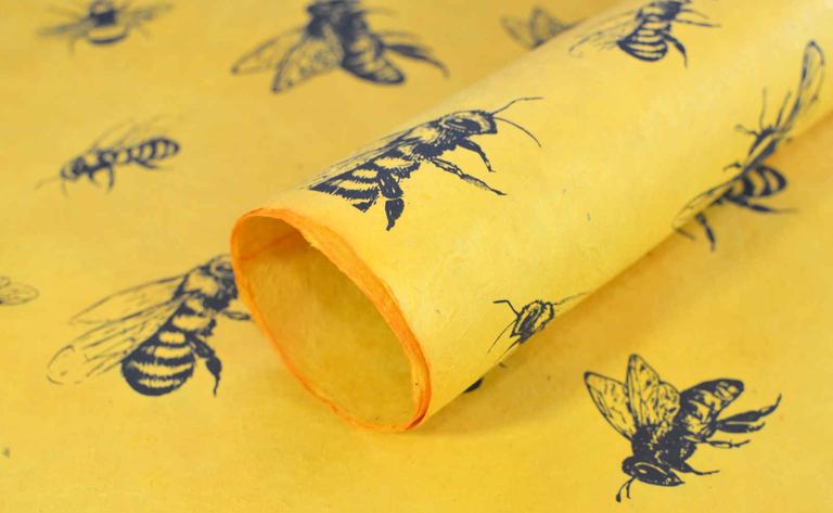 A roll of honey-yellow Busy Bee lokta wrapping paper printed with bees