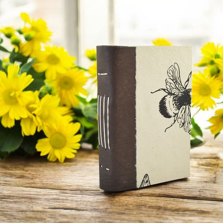 The Busy Bee Nepali Collector journal standing on a table among yellow flowers
