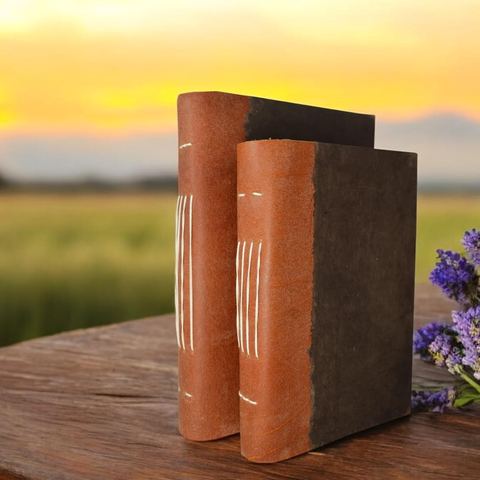 The 5 × 8 and 6 × 9 Dark Walnut Nepali Collector journals on a table at sunset