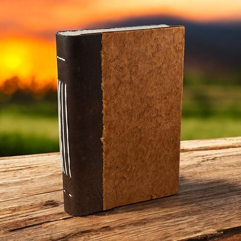 The Terra Cotta Nepali Collector journal standing on a wooden table at sunset