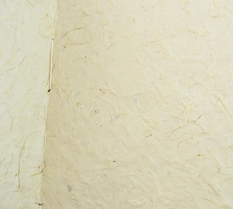 A Nepali Wayfinder journal open to a blank page of textured lokta