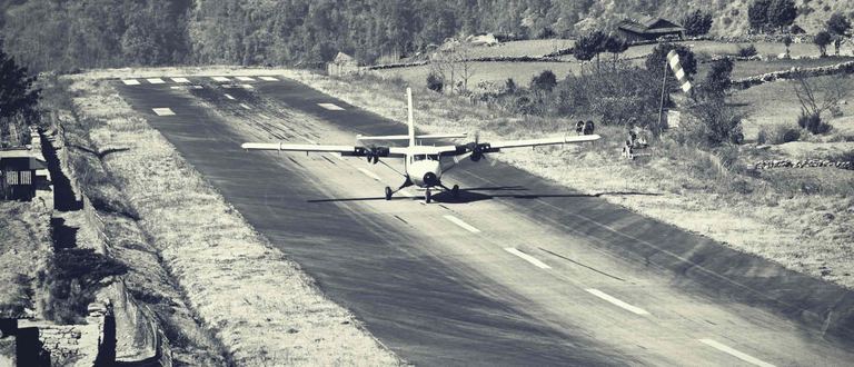 A small plane on the mountain airstrip at Lukla, in black and white