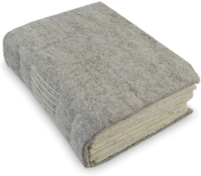 The wool felt Nepali Yeti Tracker journal, its stitched spine and deckle-edged pages showing